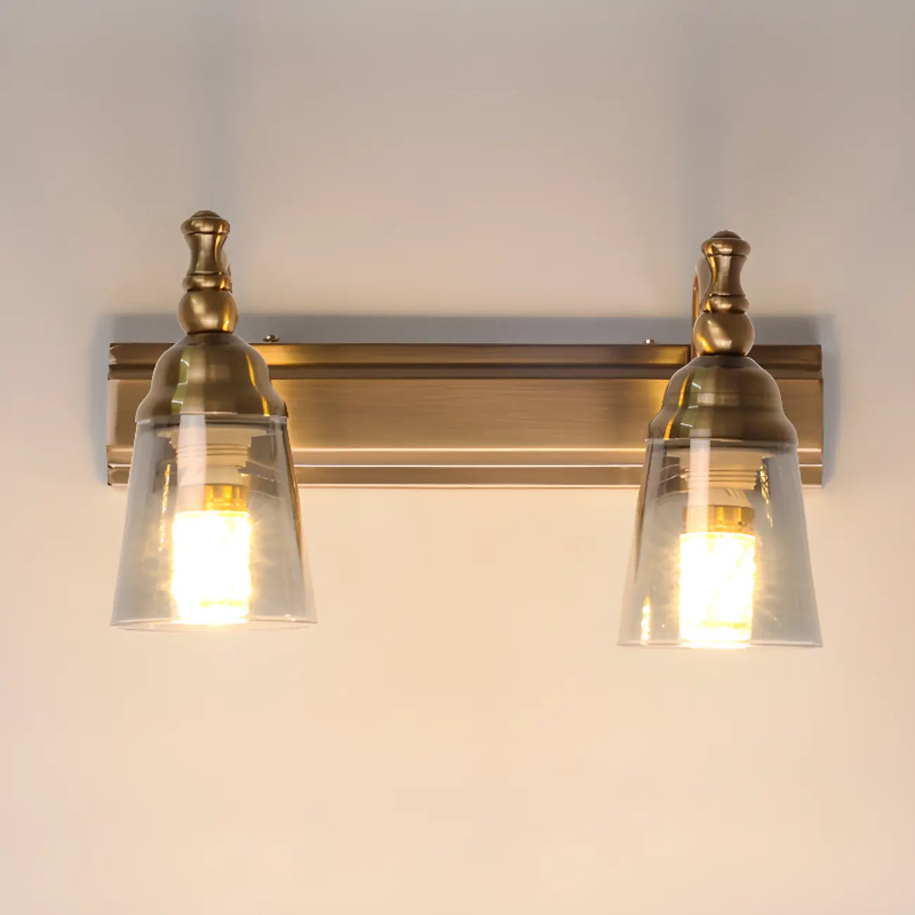 Élégantes lampes de coiffeuse géométriques en laiton au-dessus du miroir